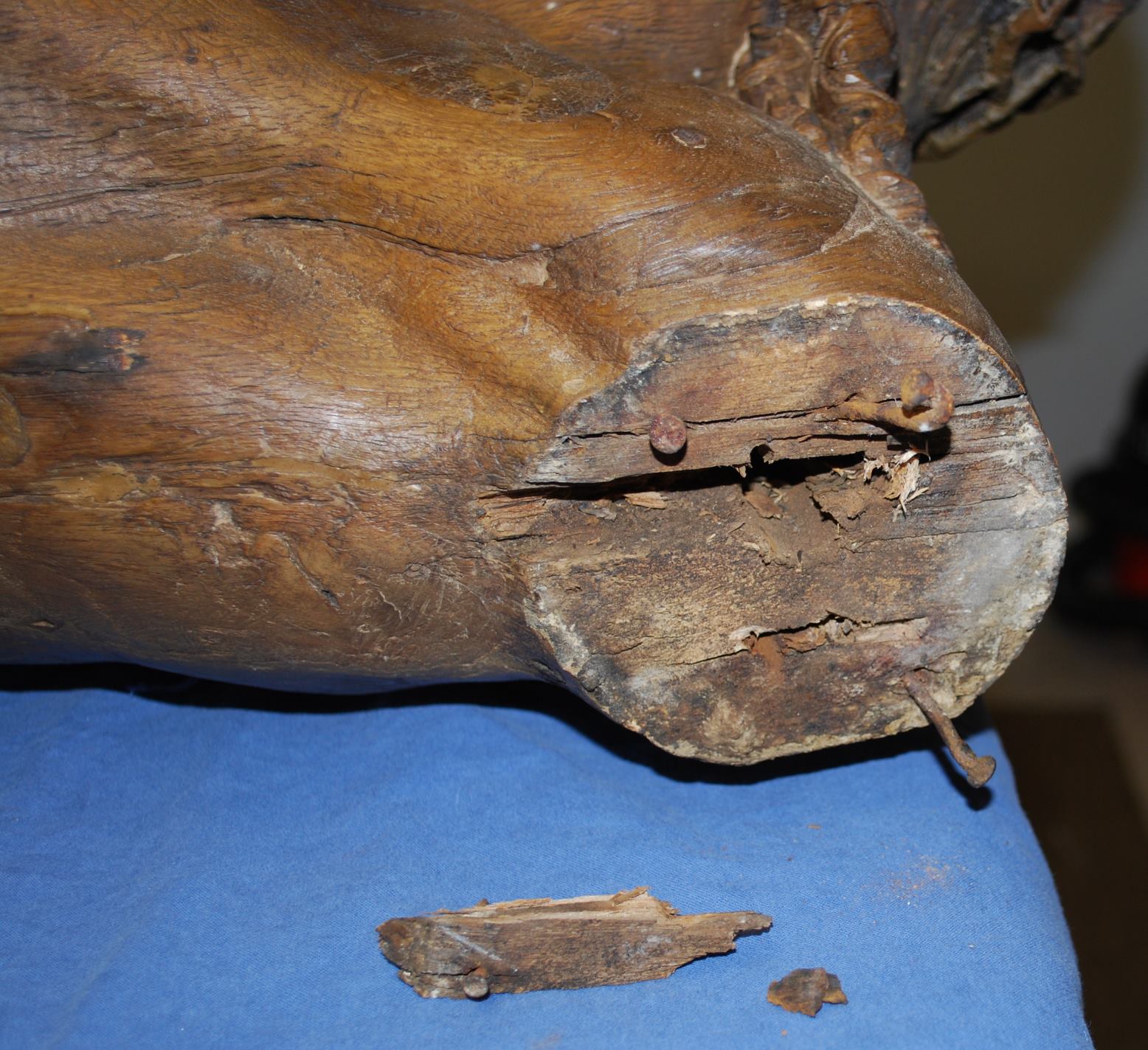 Detailansicht der Holzausbrüche und Nägel im Bereich der Armbefestigungen